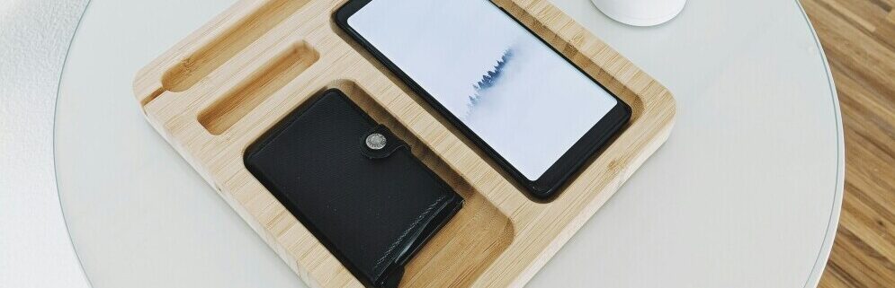 image of a mobile phone and a wallet in the respective skills of a wooden box