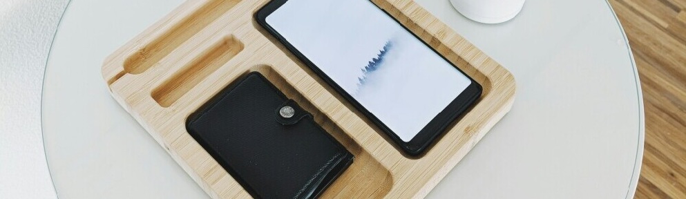 image of a mobile phone and wallet placed into slots of wooden box