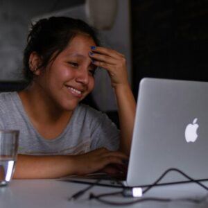 A woman looking at her laptop happily