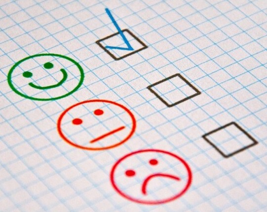 different smiley face expressions and a checkered box next to each expression