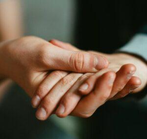 2 hands holding each other as if they were supporting each other