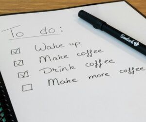 A paper with four to dos written on it. A pen was placed on top of the to do list.